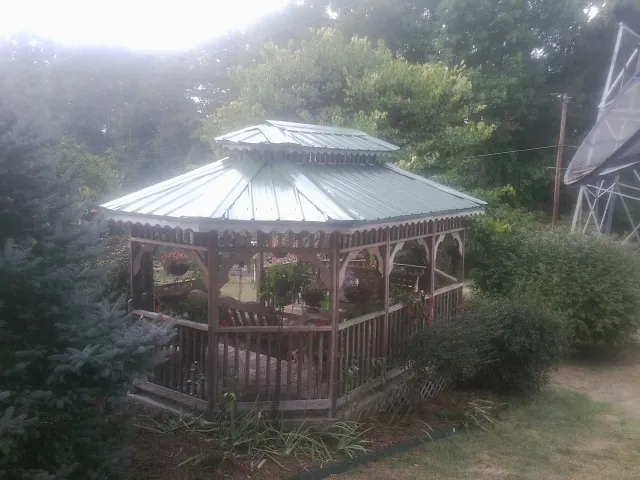 Green metal roof on a backyard gazebo surrounded by garden beds in Franklin